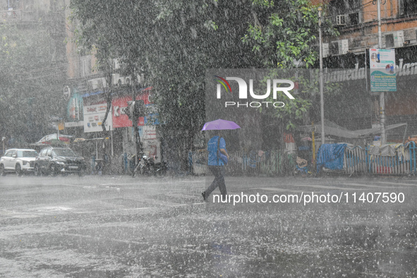 A person is crossing a street during the heavy rain in Kolkata, India, on July 14, 2024. 