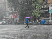 A person is crossing a street during the heavy rain in Kolkata, India, on July 14, 2024. (