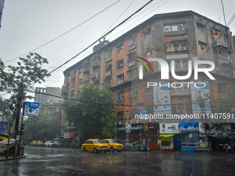 Yellow taxis are waiting at a traffic signal during the heavy rain in Kolkata, India, on July 14, 2024. (