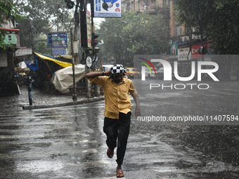 A person is running on the street during the heavy rain in Kolkata, India, on July 14, 2024. (