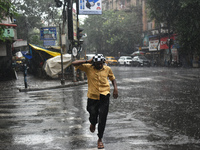 A person is running on the street during the heavy rain in Kolkata, India, on July 14, 2024. (