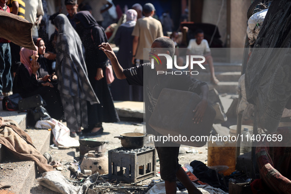 People are checking the destruction at a UN-run school after Israeli bombardment in Nuseirat, in the central Gaza Strip, on July 14, 2024, a...