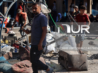 People are checking the destruction at a UN-run school after Israeli bombardment in Nuseirat, in the central Gaza Strip, on July 14, 2024, a...