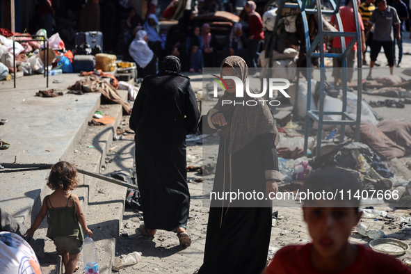 People are checking the destruction at a UN-run school after Israeli bombardment in Nuseirat, in the central Gaza Strip, on July 14, 2024, a...