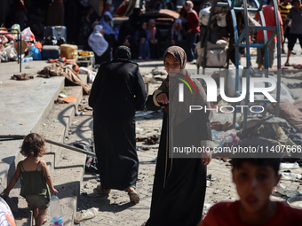 People are checking the destruction at a UN-run school after Israeli bombardment in Nuseirat, in the central Gaza Strip, on July 14, 2024, a...