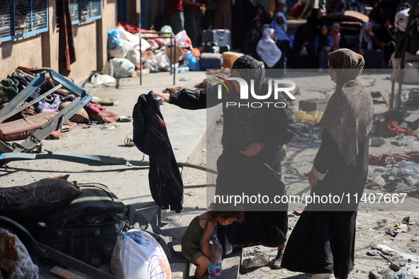 People are checking the destruction at a UN-run school after Israeli bombardment in Nuseirat, in the central Gaza Strip, on July 14, 2024, a...