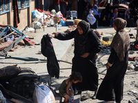 People are checking the destruction at a UN-run school after Israeli bombardment in Nuseirat, in the central Gaza Strip, on July 14, 2024, a...