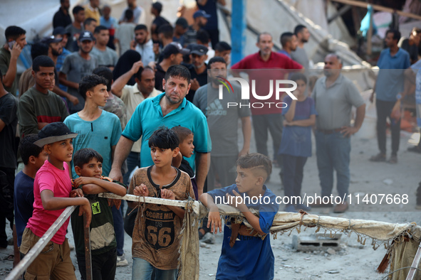 People are checking the destruction at a UN-run school after Israeli bombardment in Nuseirat, in the central Gaza Strip, on July 14, 2024, a...