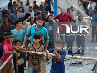 People are checking the destruction at a UN-run school after Israeli bombardment in Nuseirat, in the central Gaza Strip, on July 14, 2024, a...