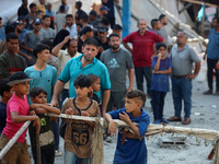 People are checking the destruction at a UN-run school after Israeli bombardment in Nuseirat, in the central Gaza Strip, on July 14, 2024, a...