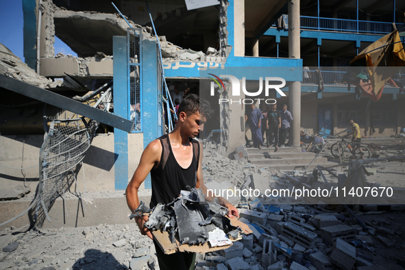 People are checking the destruction at a UN-run school after Israeli bombardment in Nuseirat, in the central Gaza Strip, on July 14, 2024, a...