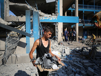 People are checking the destruction at a UN-run school after Israeli bombardment in Nuseirat, in the central Gaza Strip, on July 14, 2024, a...