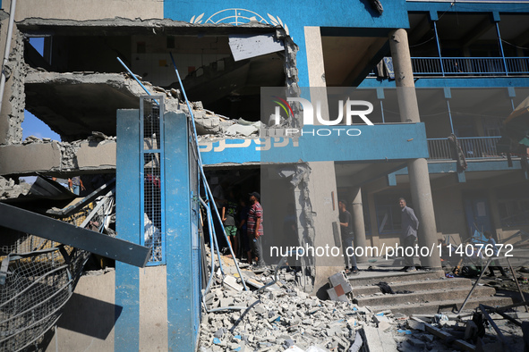 People are checking the destruction at a UN-run school after Israeli bombardment in Nuseirat, in the central Gaza Strip, on July 14, 2024, a...