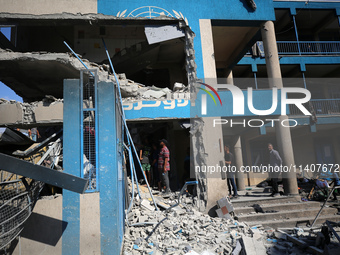 People are checking the destruction at a UN-run school after Israeli bombardment in Nuseirat, in the central Gaza Strip, on July 14, 2024, a...