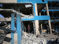 People are checking the destruction at a UN-run school after Israeli bombardment in Nuseirat, in the central Gaza Strip, on July 14, 2024, a...