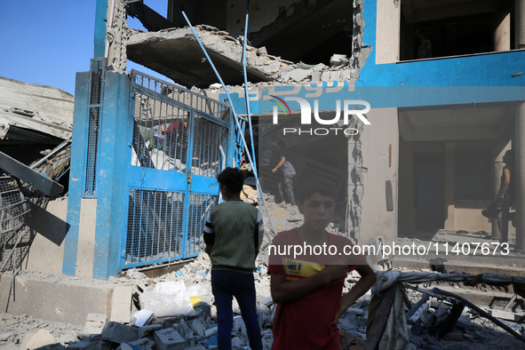 People are checking the destruction at a UN-run school after Israeli bombardment in Nuseirat, in the central Gaza Strip, on July 14, 2024, a...