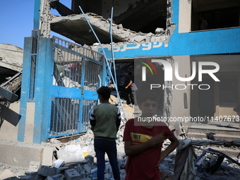 People are checking the destruction at a UN-run school after Israeli bombardment in Nuseirat, in the central Gaza Strip, on July 14, 2024, a...