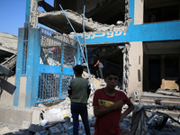 People are checking the destruction at a UN-run school after Israeli bombardment in Nuseirat, in the central Gaza Strip, on July 14, 2024, a...