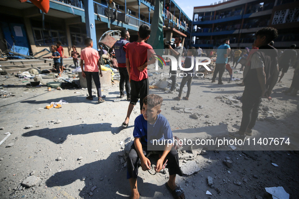 People are checking the destruction at a UN-run school after Israeli bombardment in Nuseirat, in the central Gaza Strip, on July 14, 2024, a...