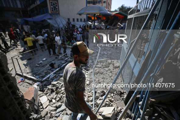 People are checking the destruction at a UN-run school after Israeli bombardment in Nuseirat, in the central Gaza Strip, on July 14, 2024, a...