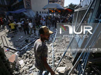 People are checking the destruction at a UN-run school after Israeli bombardment in Nuseirat, in the central Gaza Strip, on July 14, 2024, a...