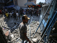 People are checking the destruction at a UN-run school after Israeli bombardment in Nuseirat, in the central Gaza Strip, on July 14, 2024, a...