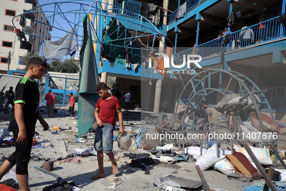 People are checking the destruction at a UN-run school after Israeli bombardment in Nuseirat, in the central Gaza Strip, on July 14, 2024, a...