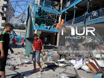 People are checking the destruction at a UN-run school after Israeli bombardment in Nuseirat, in the central Gaza Strip, on July 14, 2024, a...