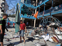 People are checking the destruction at a UN-run school after Israeli bombardment in Nuseirat, in the central Gaza Strip, on July 14, 2024, a...