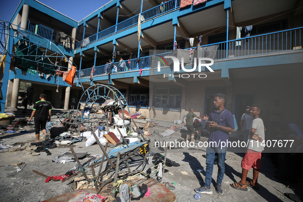 People are checking the destruction at a UN-run school after Israeli bombardment in Nuseirat, in the central Gaza Strip, on July 14, 2024, a...