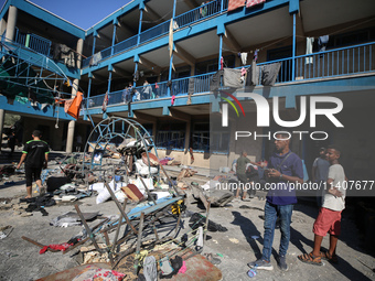 People are checking the destruction at a UN-run school after Israeli bombardment in Nuseirat, in the central Gaza Strip, on July 14, 2024, a...