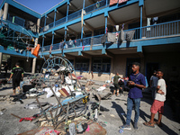 People are checking the destruction at a UN-run school after Israeli bombardment in Nuseirat, in the central Gaza Strip, on July 14, 2024, a...