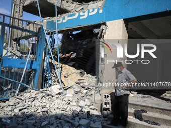 People are checking the destruction at a UN-run school after Israeli bombardment in Nuseirat, in the central Gaza Strip, on July 14, 2024, a...