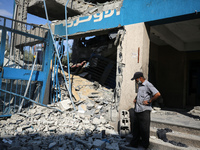 People are checking the destruction at a UN-run school after Israeli bombardment in Nuseirat, in the central Gaza Strip, on July 14, 2024, a...