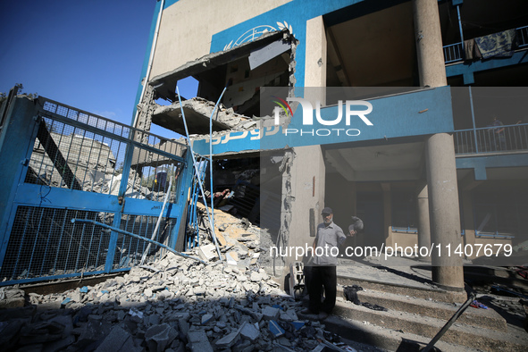 People are checking the destruction at a UN-run school after Israeli bombardment in Nuseirat, in the central Gaza Strip, on July 14, 2024, a...