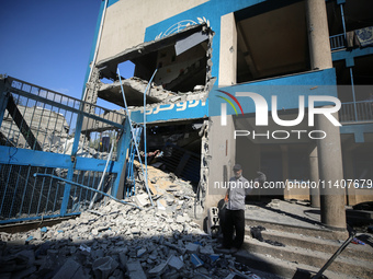 People are checking the destruction at a UN-run school after Israeli bombardment in Nuseirat, in the central Gaza Strip, on July 14, 2024, a...