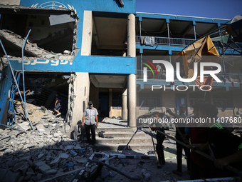 People are checking the destruction at a UN-run school after Israeli bombardment in Nuseirat, in the central Gaza Strip, on July 14, 2024, a...