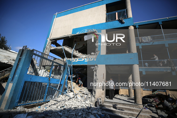 People are checking the destruction at a UN-run school after Israeli bombardment in Nuseirat, in the central Gaza Strip, on July 14, 2024, a...