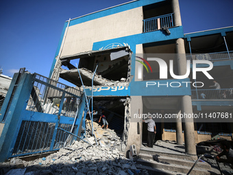 People are checking the destruction at a UN-run school after Israeli bombardment in Nuseirat, in the central Gaza Strip, on July 14, 2024, a...