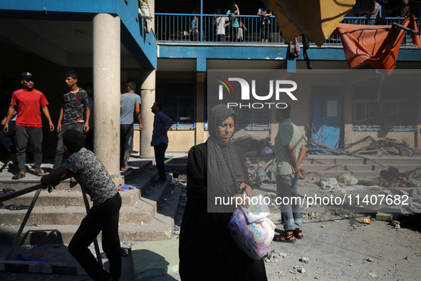 People are checking the destruction at a UN-run school after Israeli bombardment in Nuseirat, in the central Gaza Strip, on July 14, 2024, a...