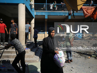 People are checking the destruction at a UN-run school after Israeli bombardment in Nuseirat, in the central Gaza Strip, on July 14, 2024, a...