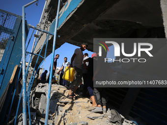 People are checking the destruction at a UN-run school after Israeli bombardment in Nuseirat, in the central Gaza Strip, on July 14, 2024, a...