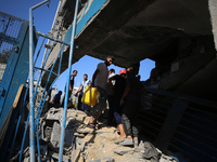 People are checking the destruction at a UN-run school after Israeli bombardment in Nuseirat, in the central Gaza Strip, on July 14, 2024, a...