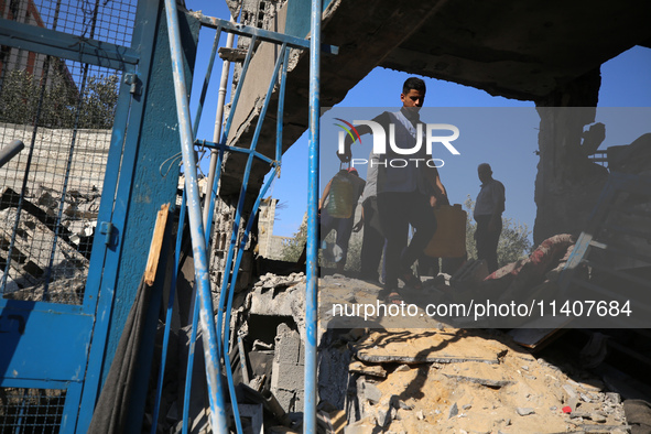 People are checking the destruction at a UN-run school after Israeli bombardment in Nuseirat, in the central Gaza Strip, on July 14, 2024, a...