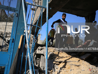 People are checking the destruction at a UN-run school after Israeli bombardment in Nuseirat, in the central Gaza Strip, on July 14, 2024, a...