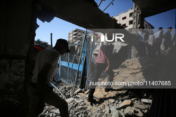 People are checking the destruction at a UN-run school after Israeli bombardment in Nuseirat, in the central Gaza Strip, on July 14, 2024, a...