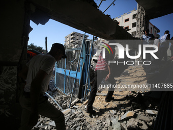 People are checking the destruction at a UN-run school after Israeli bombardment in Nuseirat, in the central Gaza Strip, on July 14, 2024, a...