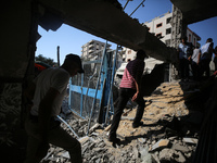 People are checking the destruction at a UN-run school after Israeli bombardment in Nuseirat, in the central Gaza Strip, on July 14, 2024, a...