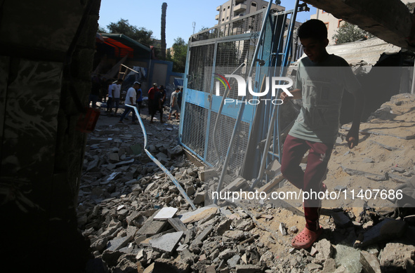 People are checking the destruction at a UN-run school after Israeli bombardment in Nuseirat, in the central Gaza Strip, on July 14, 2024, a...