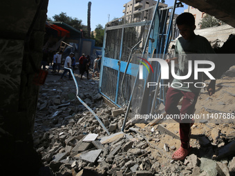 People are checking the destruction at a UN-run school after Israeli bombardment in Nuseirat, in the central Gaza Strip, on July 14, 2024, a...